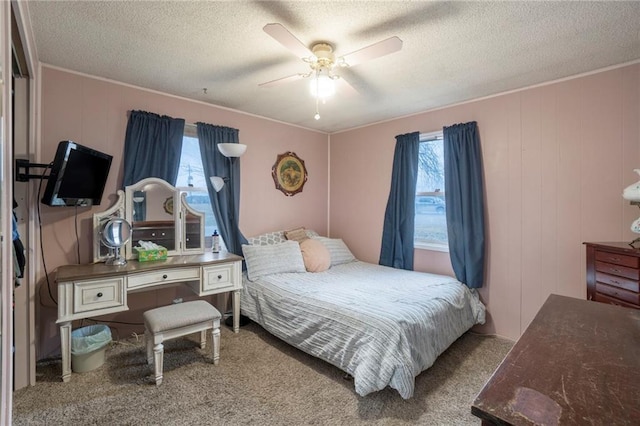 bedroom featuring ceiling fan, carpet floors, and a textured ceiling