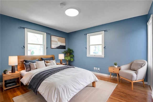 bedroom with baseboards and wood finished floors