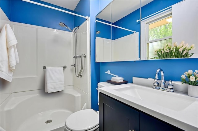 bathroom featuring toilet, walk in shower, and vanity