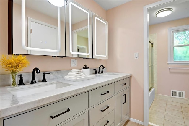 bathroom with tile patterned floors, visible vents, double vanity, and a sink
