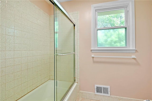 bathroom with visible vents, enclosed tub / shower combo, and baseboards