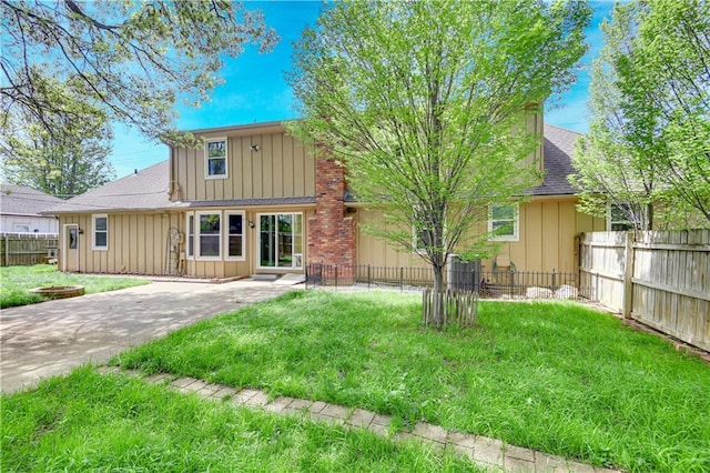 multi unit property with fence, roof with shingles, board and batten siding, and a front lawn