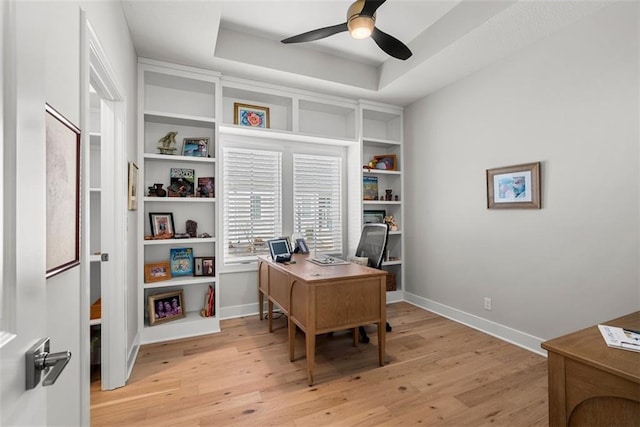 7209 Allman Dr, Shawnee, KS 66217 - home office with light wood-style flooring, ceiling fan, baseboards, and a raised ceiling