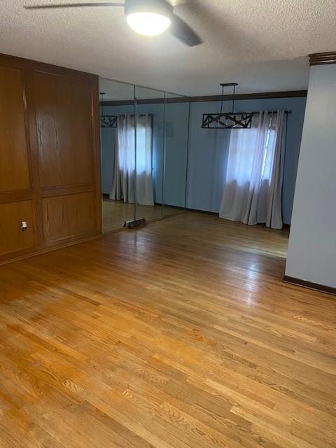 spare room featuring ceiling fan, a textured ceiling, and light wood-type flooring