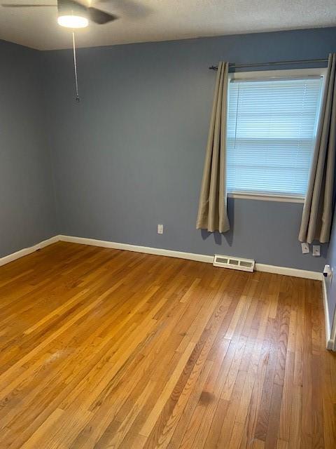 unfurnished room with wood-type flooring and ceiling fan