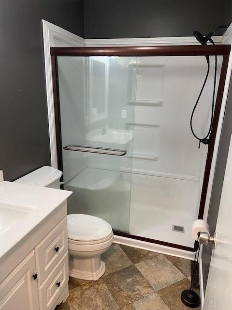 bathroom with vanity, an enclosed shower, and toilet