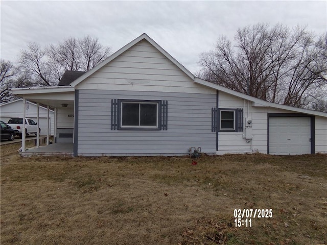 view of side of home featuring a yard and a garage