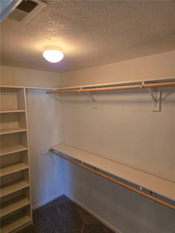 walk in closet featuring dark colored carpet and visible vents