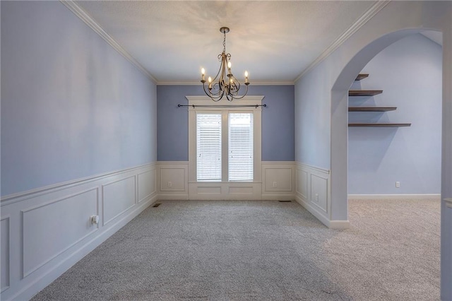 spare room featuring a chandelier, arched walkways, light carpet, and ornamental molding