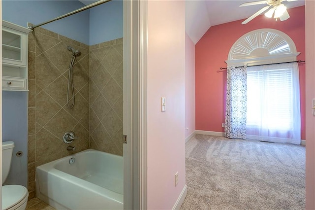 bathroom featuring lofted ceiling, toilet, a ceiling fan, tub / shower combination, and baseboards