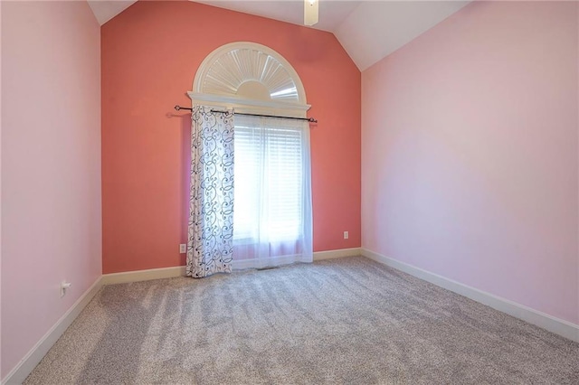 spare room with lofted ceiling, baseboards, and carpet