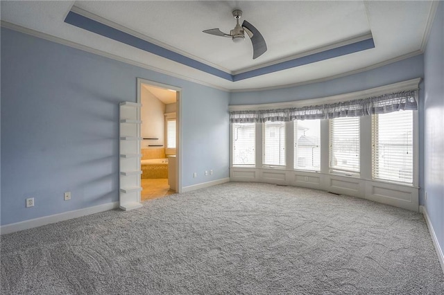 empty room with carpet, ornamental molding, and a raised ceiling