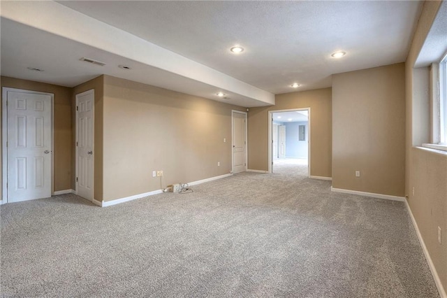 spare room with light carpet, recessed lighting, visible vents, and baseboards