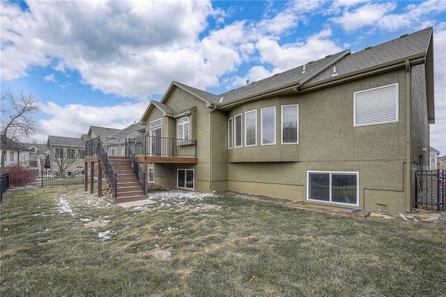 back of house with fence, stairs, a lawn, a residential view, and stucco siding