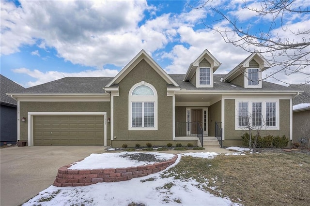 view of front of house with a garage, concrete driveway, and stucco siding