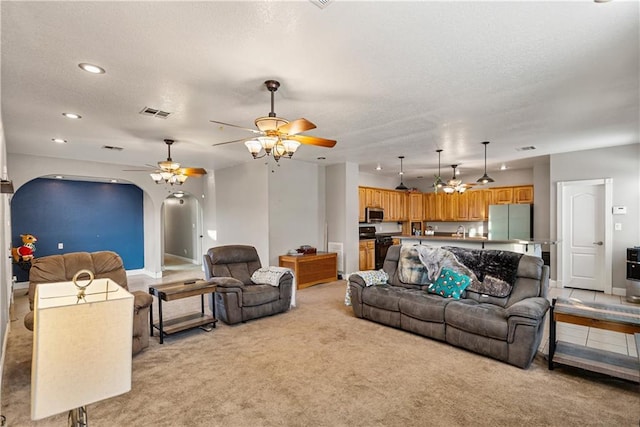 living room with light carpet, a textured ceiling, and ceiling fan