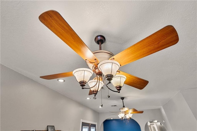 interior details featuring ceiling fan with notable chandelier