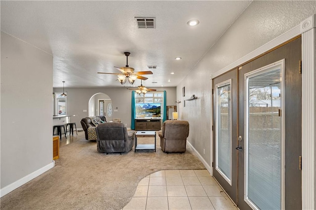 carpeted living room featuring ceiling fan, french doors, and a healthy amount of sunlight