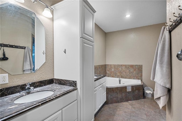 bathroom with vanity and tiled bath