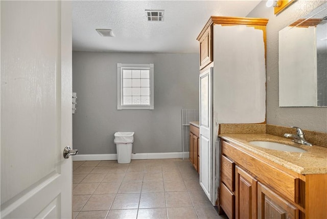 bathroom featuring vanity, tile patterned floors, and a textured ceiling