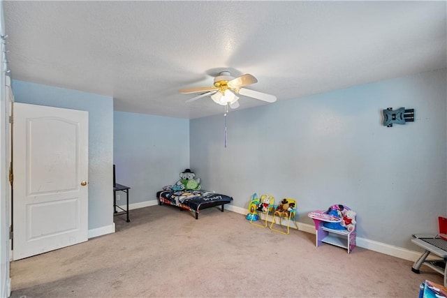 game room with ceiling fan, carpet floors, and a textured ceiling