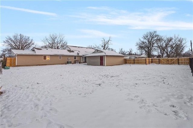 snow covered back of property featuring central AC