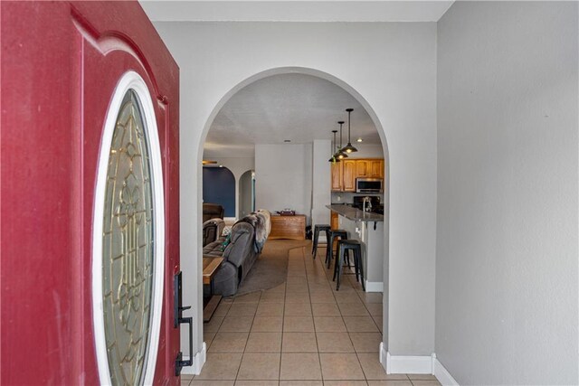 401 N Vine, Caney, KS 67333 - entrance foyer with baseboards, arched walkways, and light tile patterned floors
