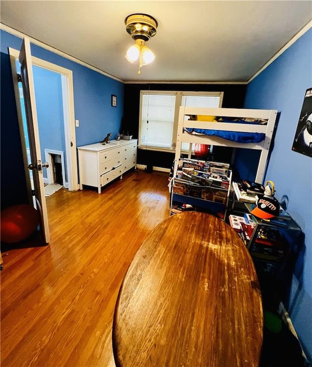 bedroom featuring ornamental molding and hardwood / wood-style floors