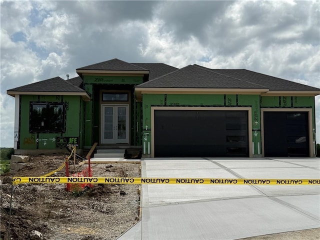 12511 W 183rd Ter, Overland Park, KS 66013 - view of front facade featuring french doors, driveway, an attached garage, a shingled roof, and stucco siding