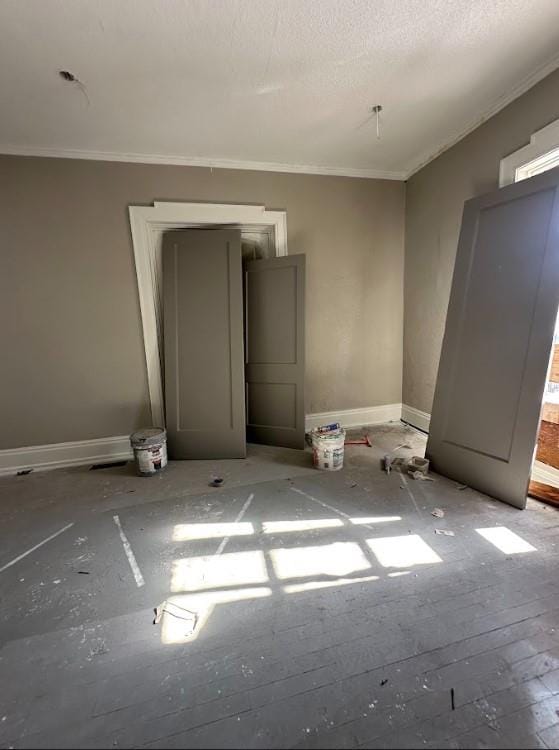 unfurnished room featuring ornamental molding and a textured ceiling