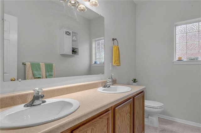 5312 Woodland Ave, Kansas City, MO 64110 - bathroom featuring vanity, toilet, and a healthy amount of sunlight