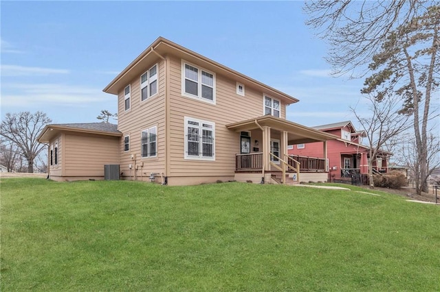 5312 Woodland Ave, Kansas City, MO 64110 - rear view of house with central AC unit, a yard, and covered porch