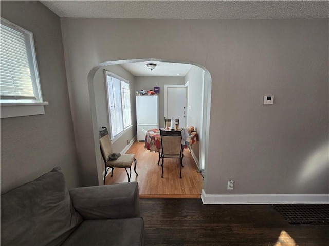 hall featuring hardwood / wood-style floors and a textured ceiling