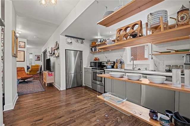 kitchen featuring open shelves, tasteful backsplash, gray cabinets, and stainless steel appliances