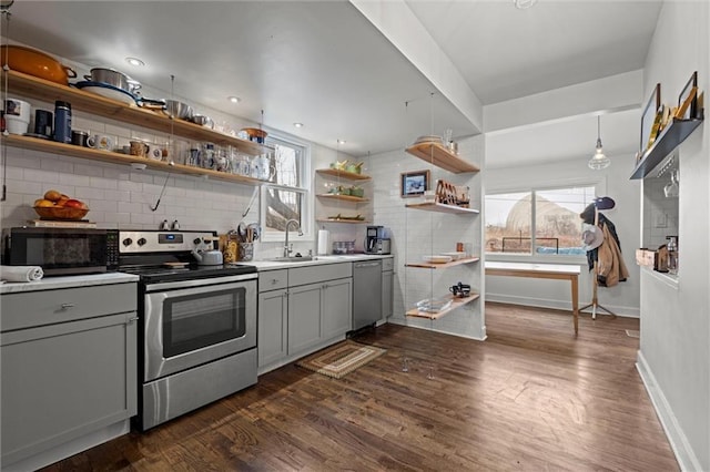 kitchen with open shelves, gray cabinetry, appliances with stainless steel finishes, a sink, and plenty of natural light