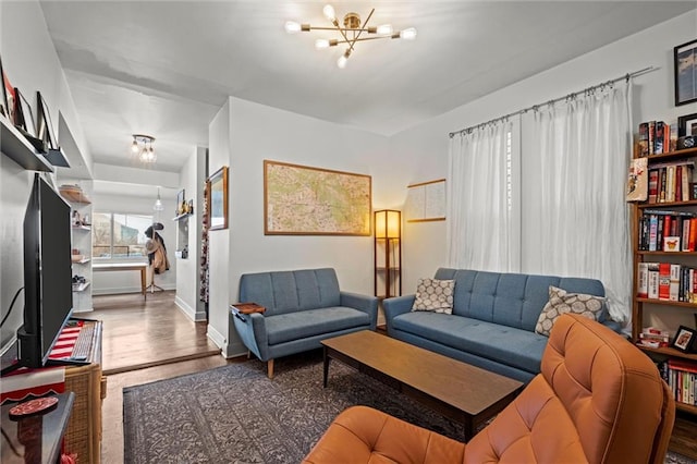 living room with an inviting chandelier, baseboards, and wood finished floors