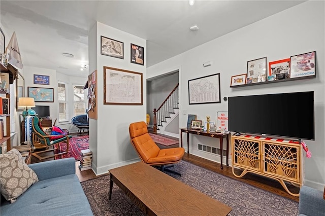 living area featuring stairway, baseboards, and wood finished floors