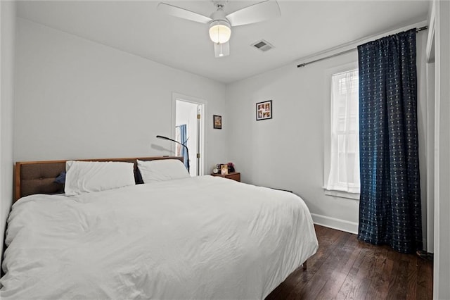 bedroom with ceiling fan, dark wood finished floors, visible vents, and baseboards