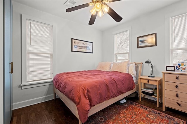 bedroom featuring hardwood / wood-style flooring, visible vents, baseboards, and multiple windows