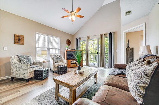 living room with light hardwood / wood-style flooring, high vaulted ceiling, and ceiling fan