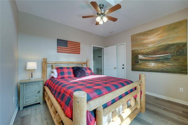 bedroom with ceiling fan, wood-type flooring, and a closet