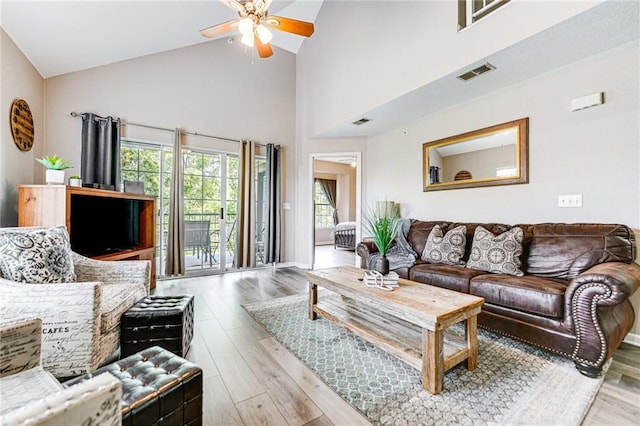 living room with light hardwood / wood-style flooring, high vaulted ceiling, and ceiling fan