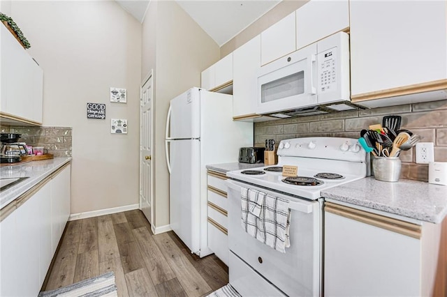 kitchen with tasteful backsplash, white cabinets, white appliances, and light hardwood / wood-style flooring