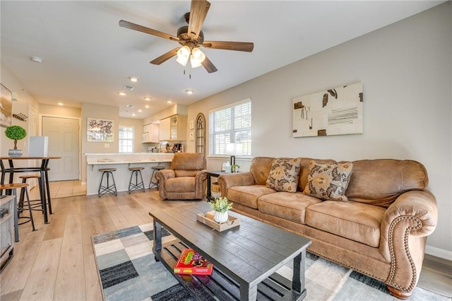 living room with ceiling fan and light wood-type flooring