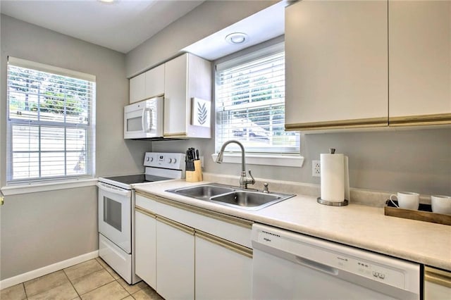 kitchen with white cabinetry, white appliances, light tile patterned flooring, and sink