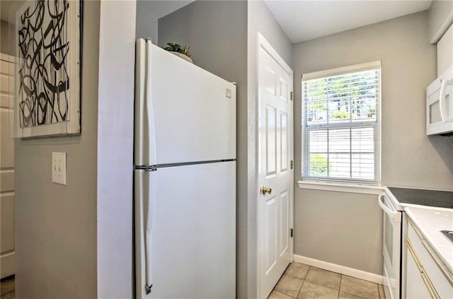 kitchen featuring light tile patterned floors and white appliances