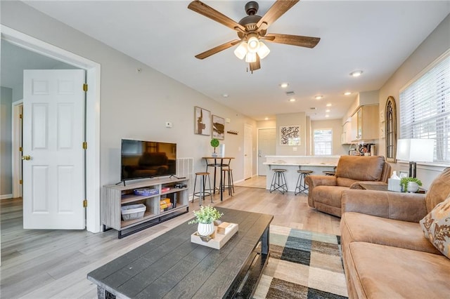 living room with ceiling fan and light hardwood / wood-style floors