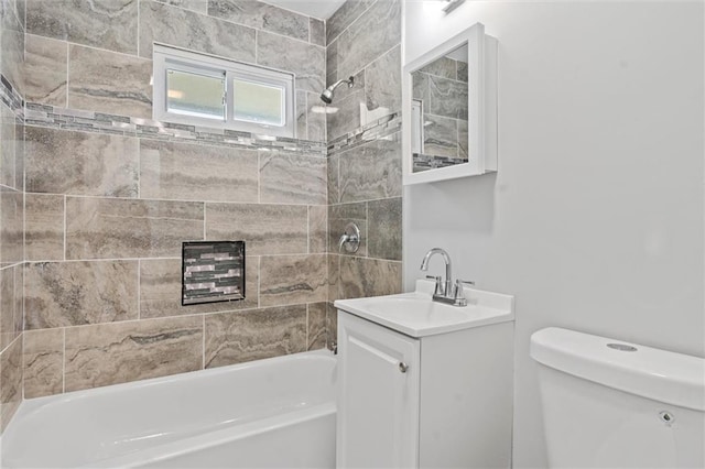 full bathroom with vanity, tiled shower / bath combo, and toilet