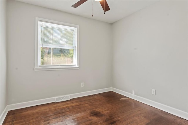 unfurnished room featuring dark wood-type flooring and ceiling fan