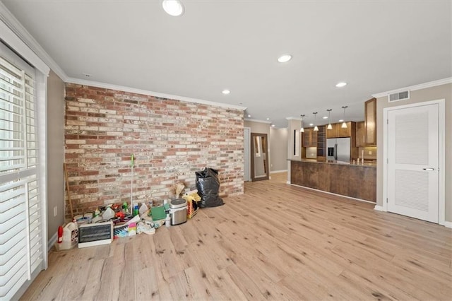 unfurnished living room with light wood finished floors, brick wall, and ornamental molding